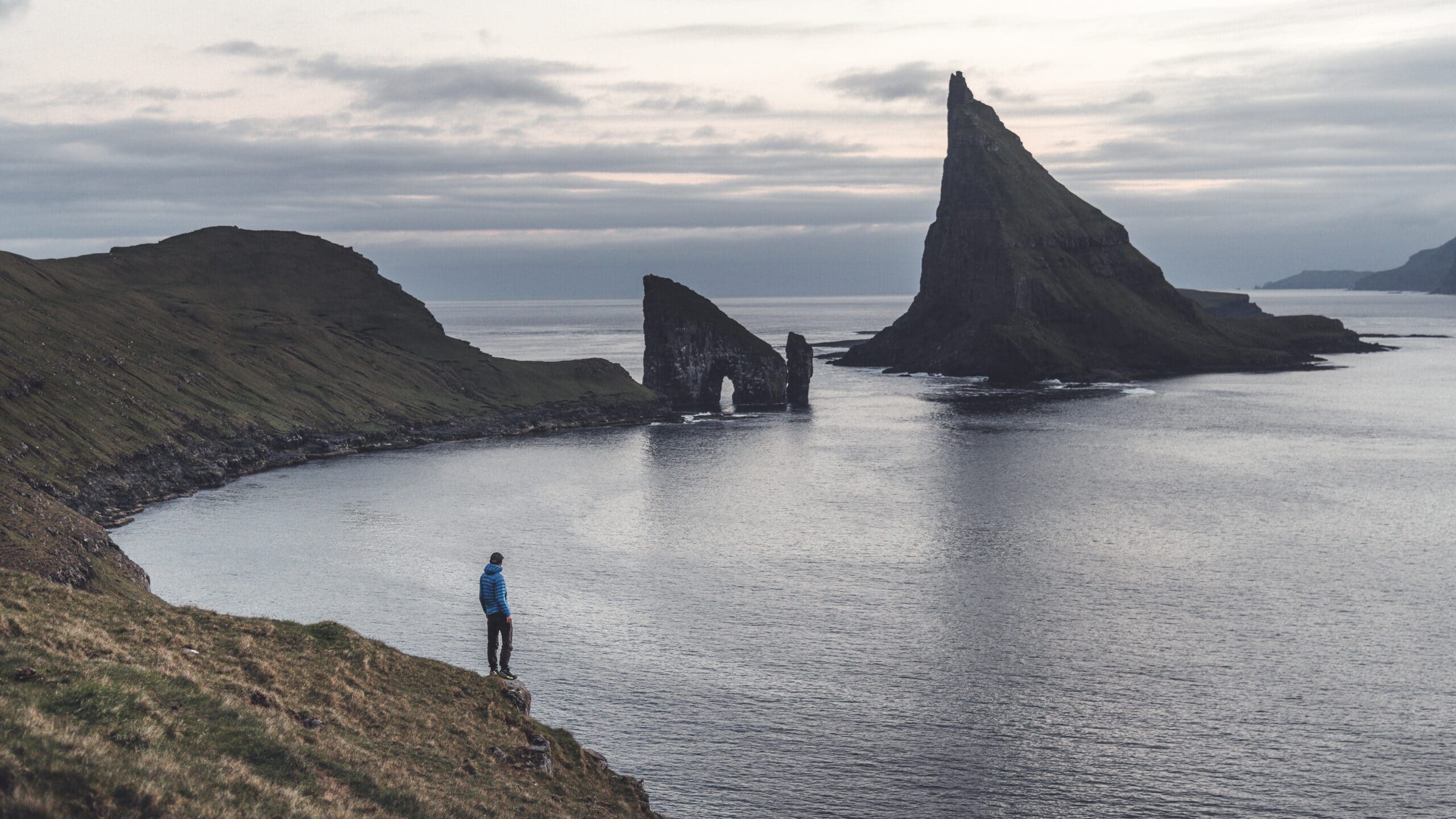 A person hiking in the Faroe Islands, preparing for a Drangarnir adventure